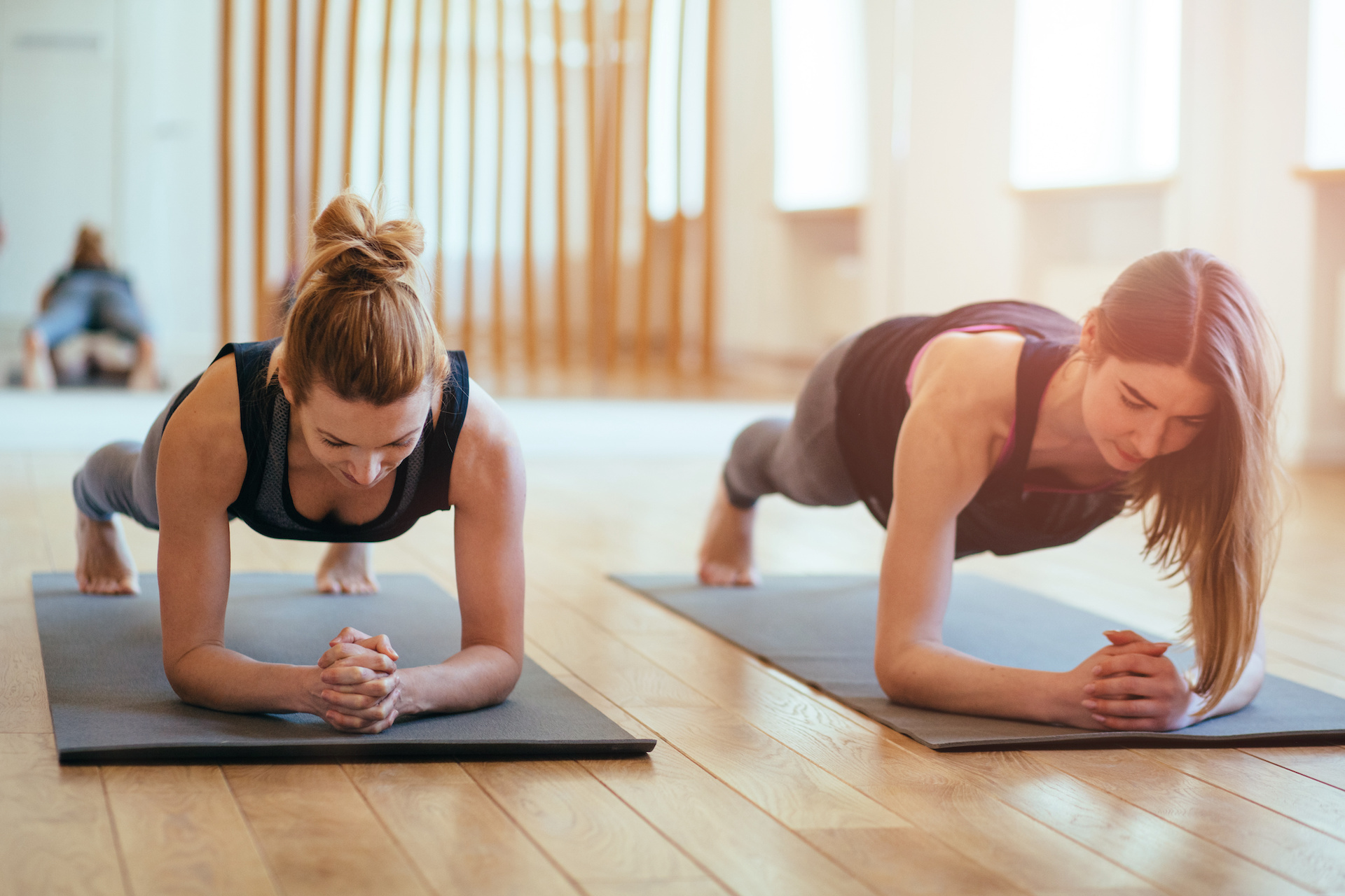 Zwei Frauen machen eine Plank-Übung, Rückbildungskurs