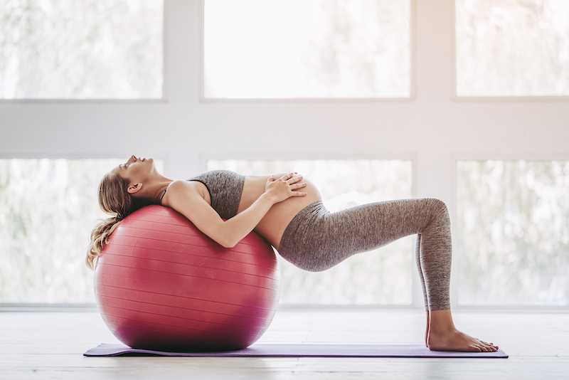 Schwangere auf Peziball bei Yogaübung